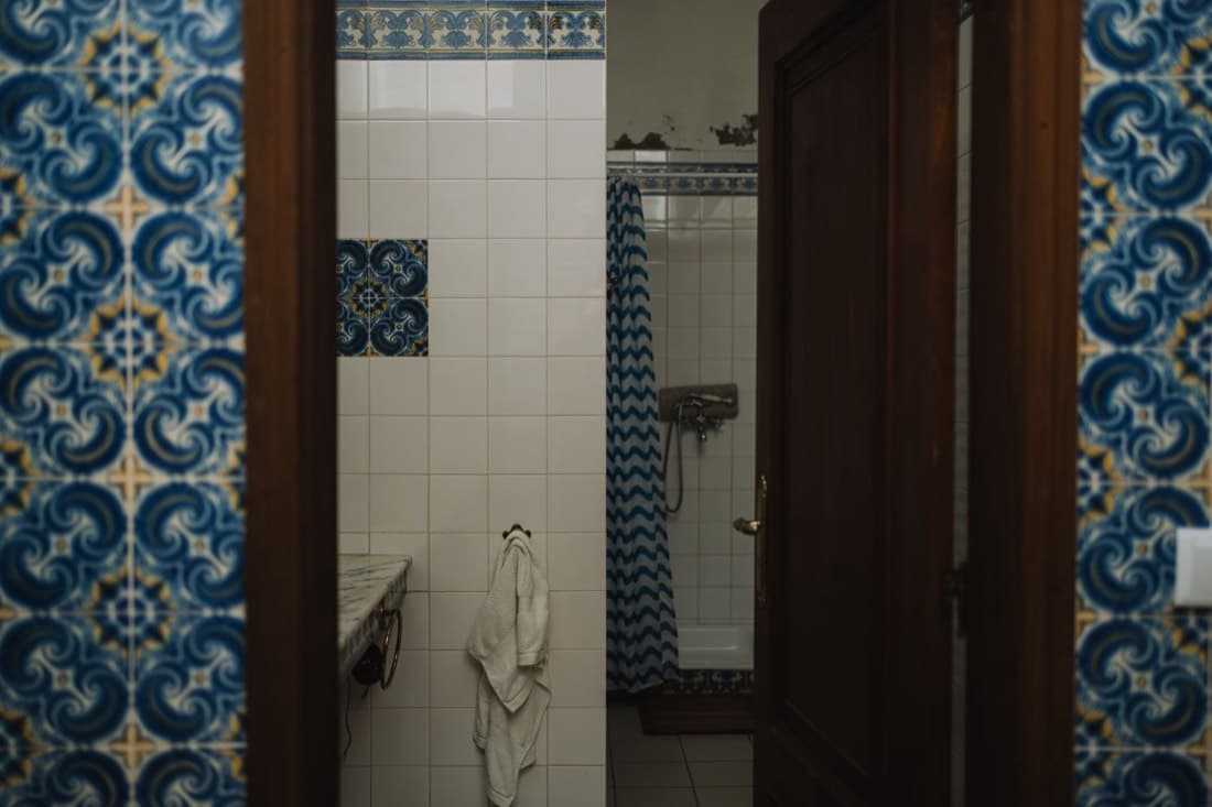 Bagno anni ’60 con piastrelle decorate e vasca, prima dei lavori